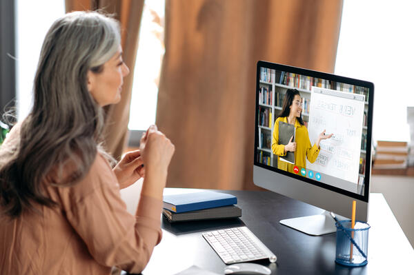 Mature Woman Watching Video Screen Presentation by Financial Counselor