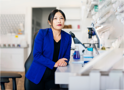 woman sitting next to microscopes
