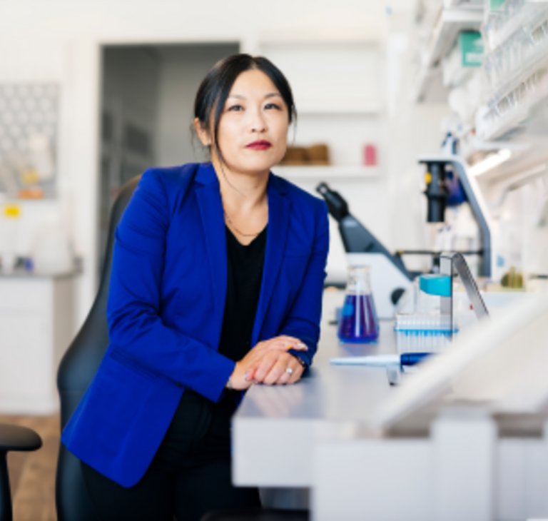 woman sitting next to microscopes