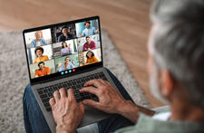 Mature Man Participating in a Virtual Meeting on His Lap