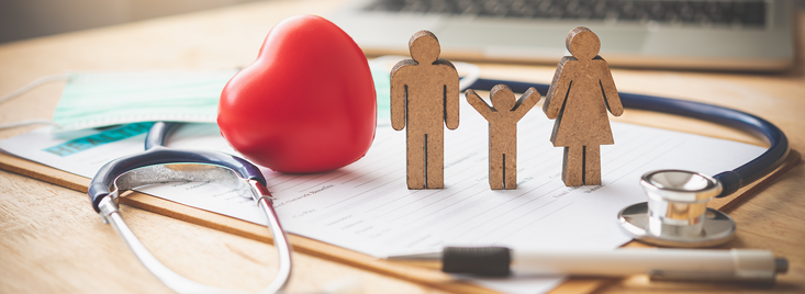 Medical Insurance Concept With Family Paper Cutouts And Stethoscope On Wooden Desk